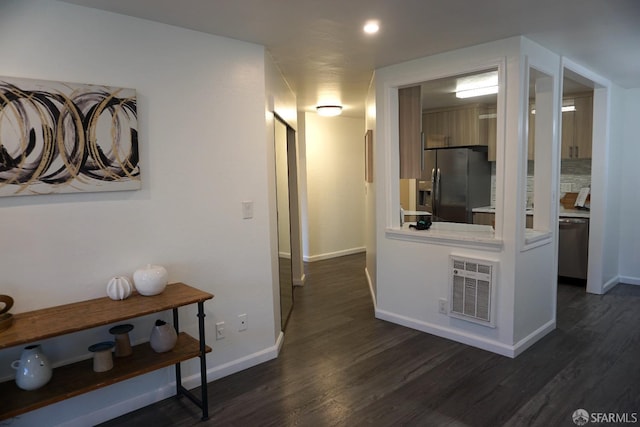 hall with visible vents, baseboards, and dark wood-style flooring