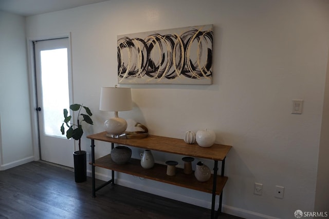 interior space featuring baseboards and wood finished floors