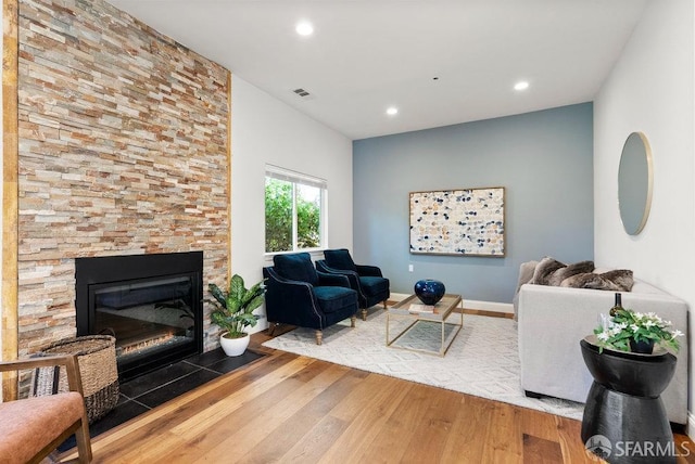 living area featuring recessed lighting, visible vents, wood finished floors, and a fireplace