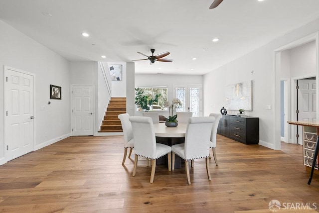 dining space with a ceiling fan, recessed lighting, light wood finished floors, and stairway