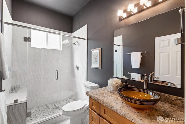 bathroom with vanity, toilet, and a shower stall
