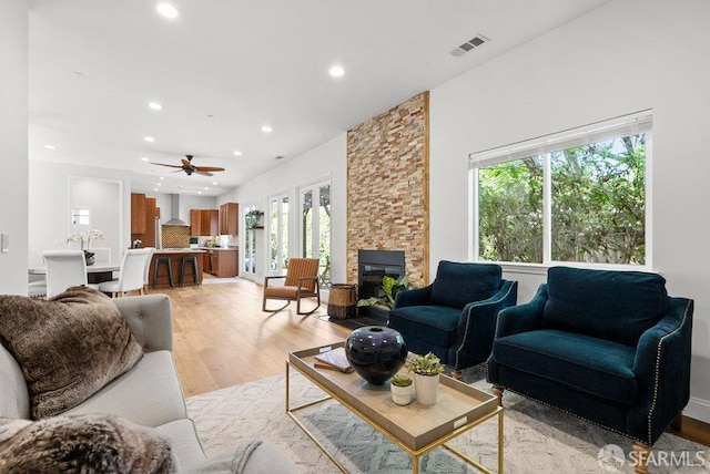 living room featuring recessed lighting, light wood-style flooring, ceiling fan, and visible vents
