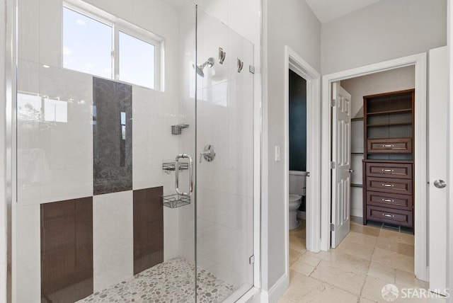 bathroom featuring a stall shower and toilet