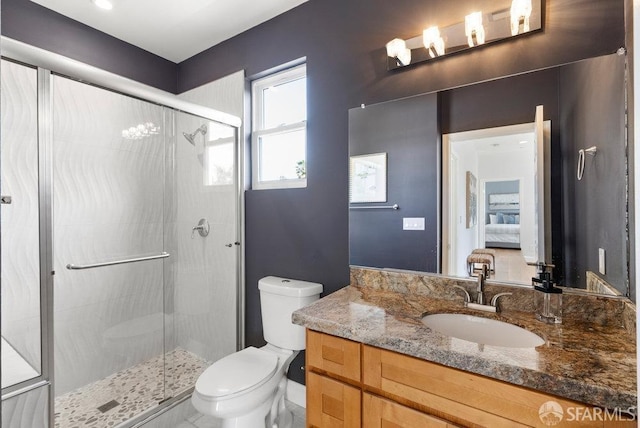 full bathroom with vanity, a shower stall, and toilet