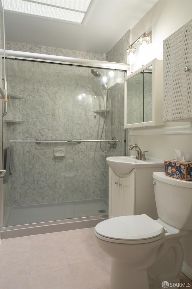 bathroom featuring tile patterned flooring, vanity, a shower with shower door, and toilet