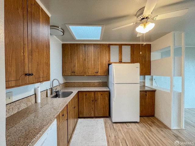 kitchen with sink, white appliances, light hardwood / wood-style flooring, and ceiling fan