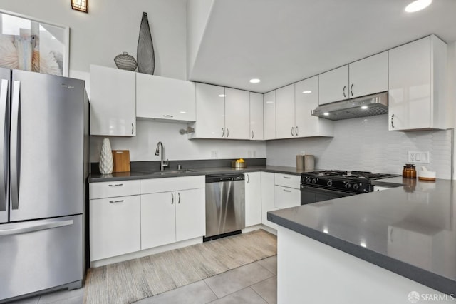 kitchen featuring white cabinetry, sink, tasteful backsplash, light tile patterned floors, and appliances with stainless steel finishes