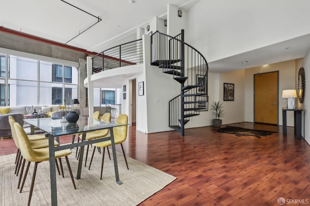 dining area with a high ceiling and hardwood / wood-style flooring