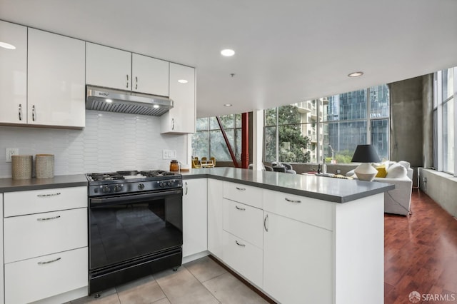 kitchen with white cabinets, backsplash, kitchen peninsula, and black range with gas cooktop