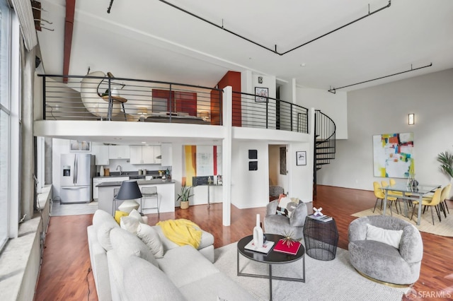 living room with a towering ceiling and wood-type flooring