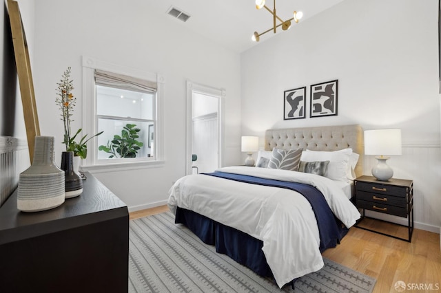 3031 20th St, San Francisco, CA 94110 - bedroom with a chandelier, wood finished floors, and baseboards