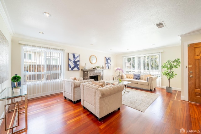 living area with a wealth of natural light, dark wood-type flooring, a fireplace, and visible vents