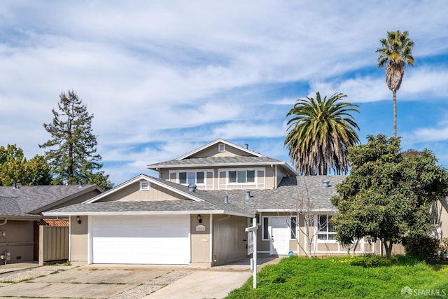 view of front facade featuring an attached garage, a shingled roof, fence, and concrete driveway