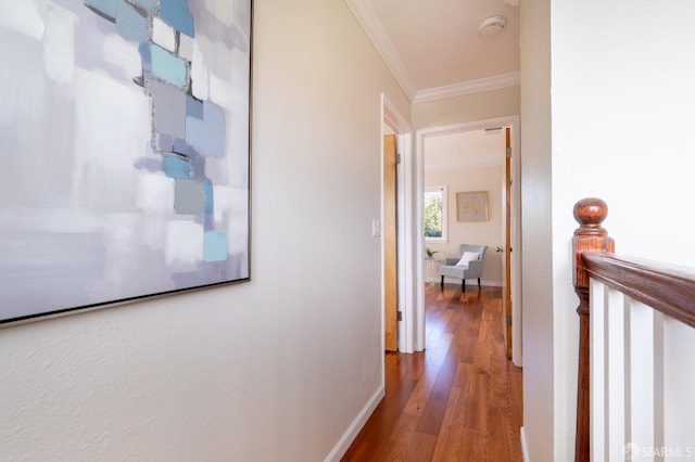 corridor featuring ornamental molding, baseboards, and wood finished floors