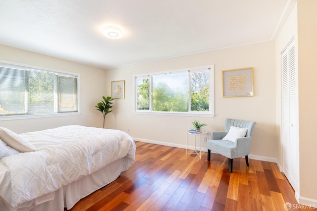 bedroom featuring a closet, wood finished floors, and baseboards