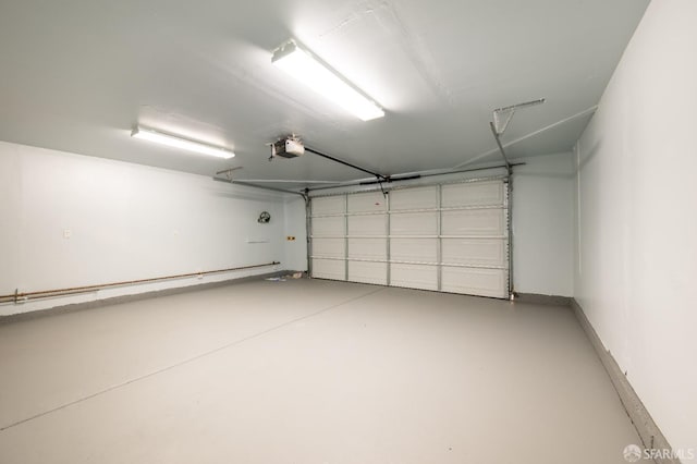 garage with baseboards and a garage door opener