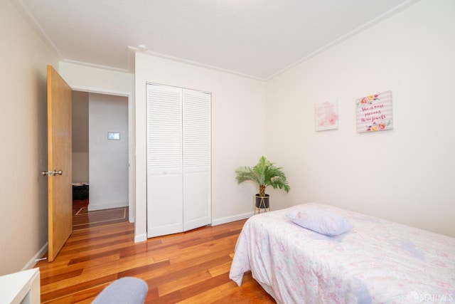 bedroom with baseboards, a closet, and light wood-style floors