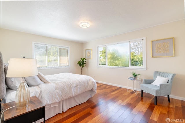 bedroom with wood finished floors and baseboards