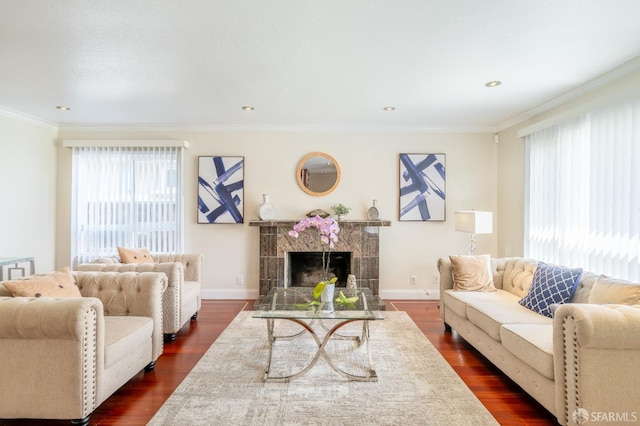 living room featuring crown molding, a tiled fireplace, baseboards, and dark wood-style flooring