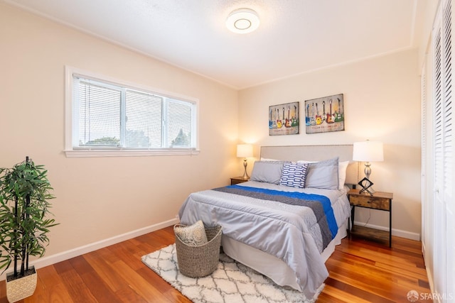 bedroom featuring wood finished floors and baseboards