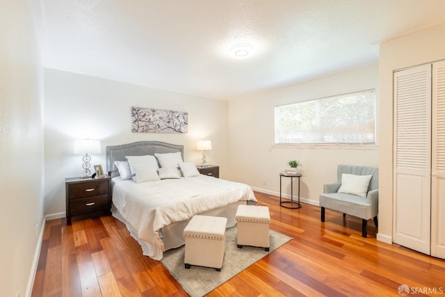 bedroom featuring wood-type flooring and baseboards