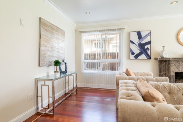 living area with a high end fireplace, crown molding, baseboards, and wood finished floors