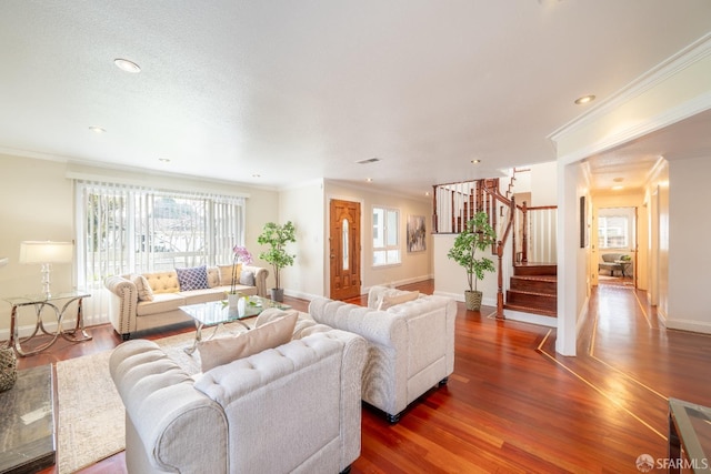 living area featuring dark wood-style flooring, crown molding, and stairway