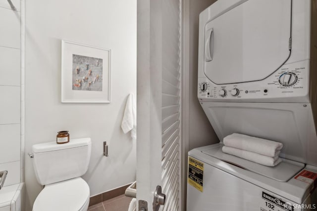 laundry room with stacked washing maching and dryer and tile patterned flooring