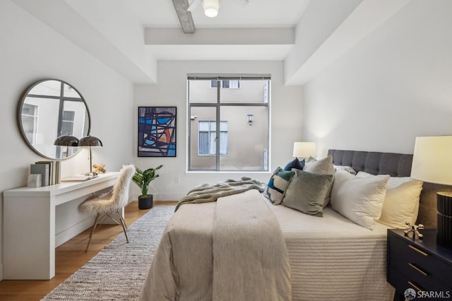 bedroom featuring beamed ceiling and light hardwood / wood-style floors