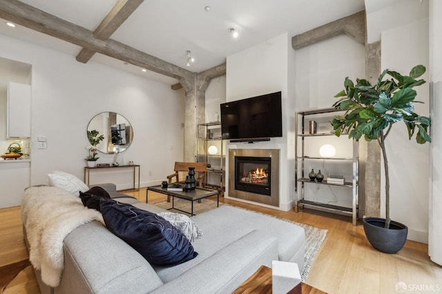 living room with beam ceiling and light wood-type flooring