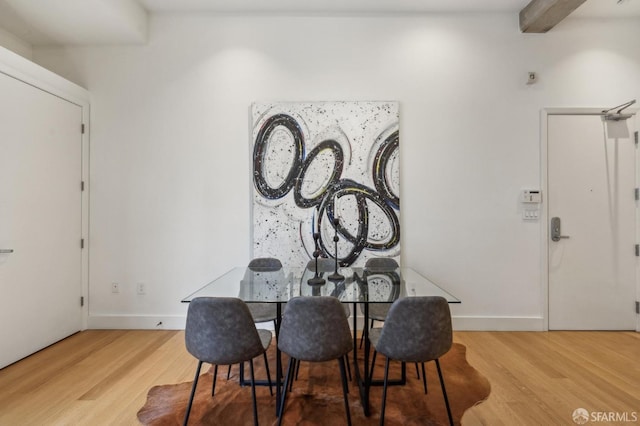 dining space featuring beam ceiling and hardwood / wood-style floors