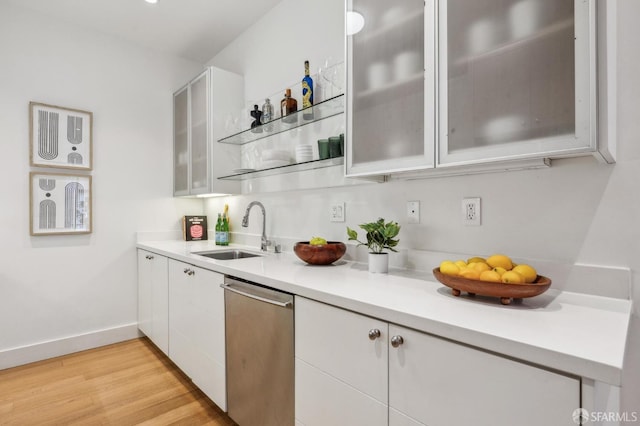 kitchen with dishwasher, sink, white cabinets, and light wood-type flooring