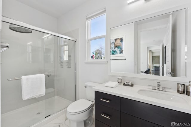 bathroom with a shower with shower door, toilet, and vanity