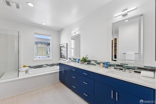 bathroom with a bath, tile patterned flooring, decorative backsplash, and vanity