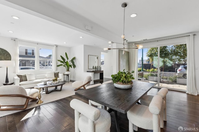 dining room with a wealth of natural light, dark hardwood / wood-style flooring, and a chandelier