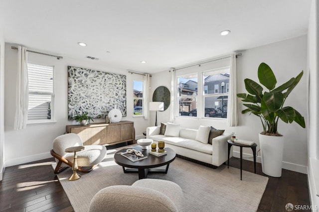 living room with dark wood-type flooring and a wealth of natural light