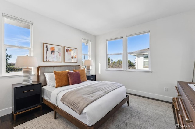 bedroom with multiple windows and hardwood / wood-style floors