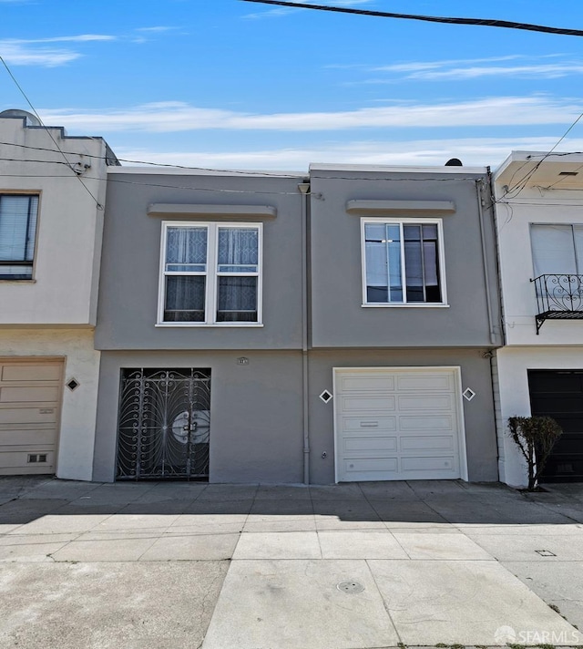 1187 Hollister St, San Francisco, CA 94124 - view of property with a garage, concrete driveway, and stucco siding