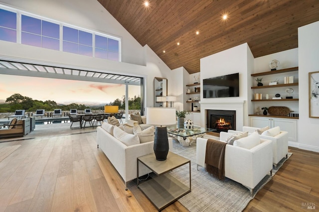 living room featuring light hardwood / wood-style flooring, a high ceiling, and wooden ceiling