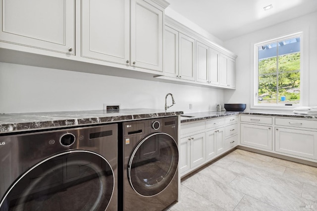 clothes washing area with cabinets, washer and dryer, and sink