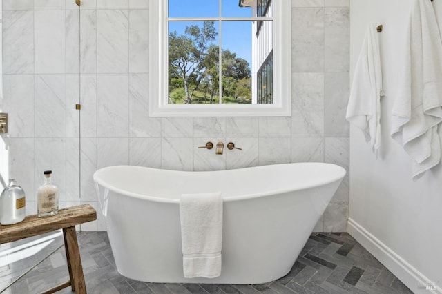 bathroom featuring tile walls and a bath