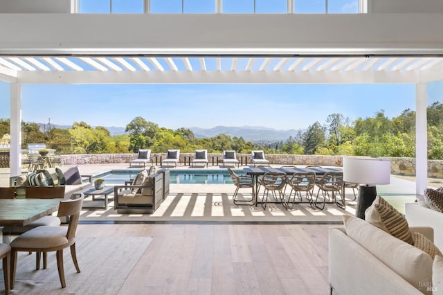 view of patio / terrace featuring a pool with hot tub, an outdoor living space, a pergola, and a mountain view