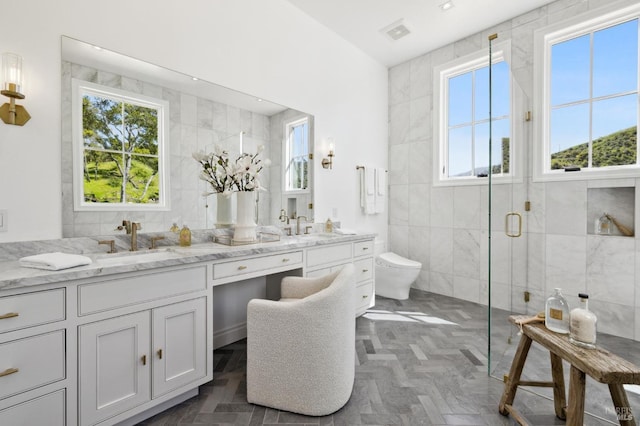 bathroom with a shower with shower door, tile walls, toilet, and vanity