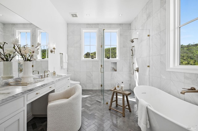 bathroom featuring vanity, tile walls, plenty of natural light, and shower with separate bathtub