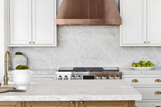 kitchen featuring white cabinetry, backsplash, stainless steel gas stovetop, and wall chimney exhaust hood