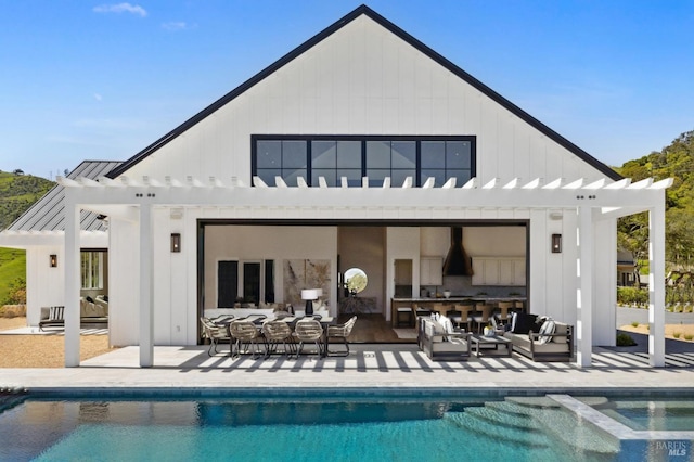 back of property with an outbuilding, a patio, an outdoor living space, and a pergola