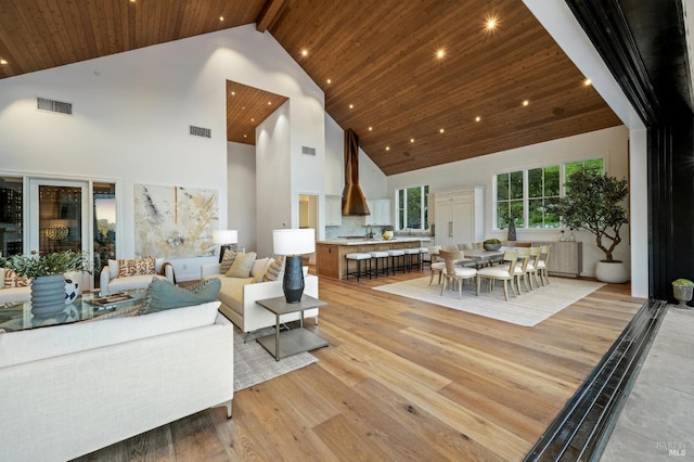 living room featuring high vaulted ceiling, light hardwood / wood-style floors, and wood ceiling