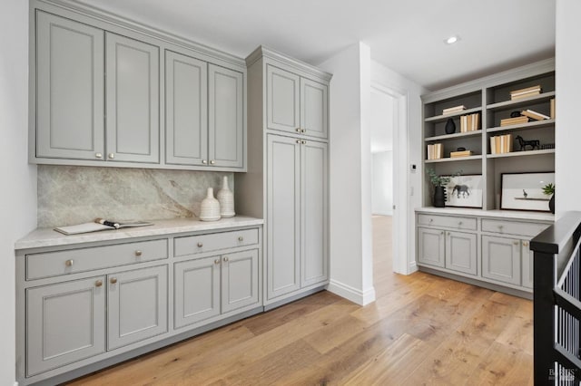 kitchen featuring decorative backsplash, light hardwood / wood-style flooring, and gray cabinets