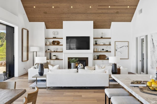 living room featuring high vaulted ceiling, light wood-type flooring, and wood ceiling