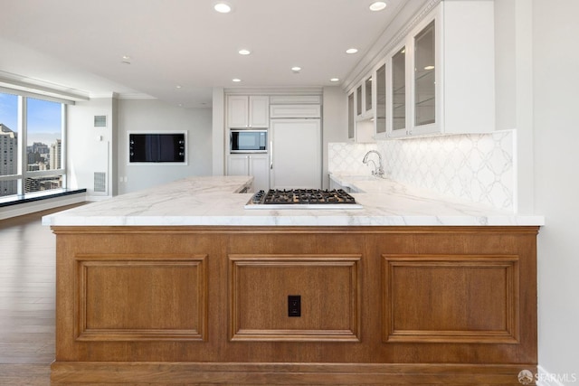 765 Market St Unit 25G, San Francisco, CA 94103 - kitchen with stainless steel gas stovetop, black microwave, a peninsula, glass insert cabinets, and decorative backsplash